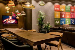 a wooden table in a restaurant with chairs and lights at Motel One Bonn-Hauptbahnhof in Bonn