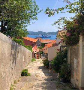 an alley with houses and a boat in the water at Via della Campana 17 in Portoferraio