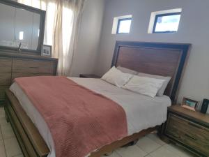 a bedroom with a large bed with a wooden headboard at Home far away from Home in Roodepoort