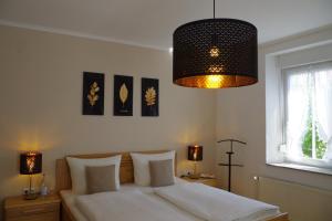 a bedroom with a large bed with a chandelier at Gast und Weinhof Beim Schneemann in Valwig