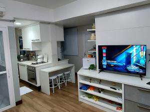 a kitchen with a flat screen tv on a counter at Apart-Hotel na Praia do Farol da Barra in Salvador