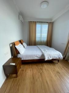 sypialnia z łóżkiem, stołem i oknem w obiekcie Victoria Entire Apartment With Gym and Pool w mieście Dar es Salaam