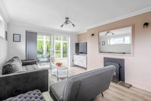 a living room with a couch and a fireplace at Waterside Cottage - Hot Tub, Mooring, Arcade, Bar in Neatishead