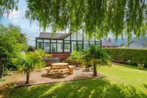 a backyard with a picnic table and a house at Waterside Cottage - Hot Tub, Mooring, Arcade, Bar in Neatishead
