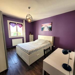 - une chambre avec un lit et un mur violet dans l'établissement Le Libé, à Grenoble