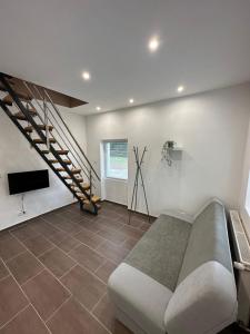 a living room with a couch and a staircase at aPart mellett in Balatonfůzfő
