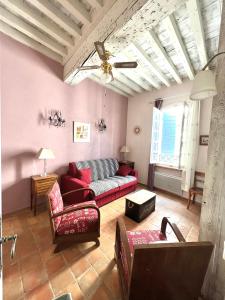 a living room with a red couch and chairs at à St Rémy Petite maison au coeur du village in Saint-Rémy-de-Provence
