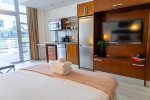 Habitación con cama, TV y cocina. en King bed Rooftop Suite Ocean Dr en Miami Beach