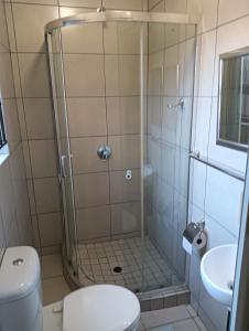 a bathroom with a shower with a toilet and a sink at Prison View Guesthouse 2 in Klerksdorp
