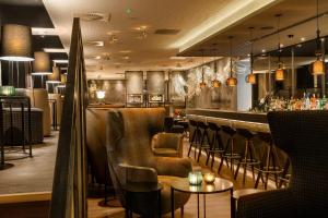 a restaurant with a bar with leather chairs and tables at Motel One Manchester-Royal Exchange in Manchester
