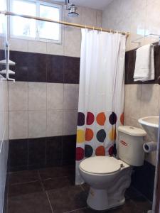 a bathroom with a toilet and a shower curtain at Casa Playa San Jacinto Manabi in San Jacinto