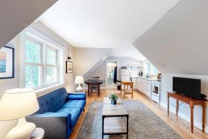 Una sala de estar con un sofá azul y una mesa. en Quarters on Main, en Castine