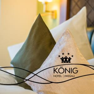 ein Kissen mit einem kong Hotel-Logo auf einem Bett in der Unterkunft Hotel König in Passau