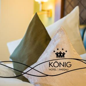 a pillow with a kong hotel logo on a bed at Hotel König in Passau