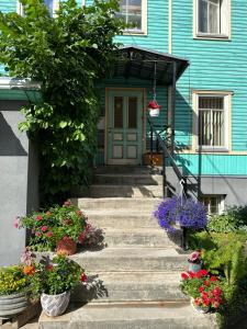 a blue house with stairs and flowers in front of it at Center of city apartments, bus station 1min, airport 5 min in Tallinn