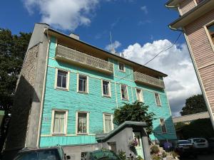 a blue building with white windows on a street at Center of city apartments, bus station 1min, airport 5 min in Tallinn +17 photos