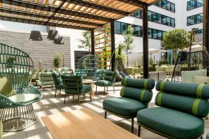 a patio with chairs and tables and a building at Motel One Stuttgart-Hauptbahnhof in Stuttgart