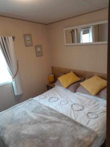 ein Schlafzimmer mit einem weißen Bett mit gelben Kissen und einem Fenster in der Unterkunft Happy place no4 in Ringwood