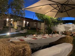 ウッジャーノ・ラ・キエーザにあるMasseria Capeceの庭に置かれたテーブルとグラスと傘