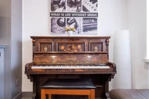 um piano velho numa sala com uma foto na parede em Home in Peterborough em Peterborough