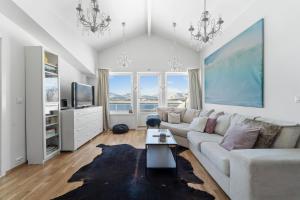 a living room with a white couch and a tv at Central Panoramic Retreat in Tromsø