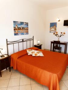 1 dormitorio con 1 cama con manta naranja en La Mimosa di Erice, en Erice