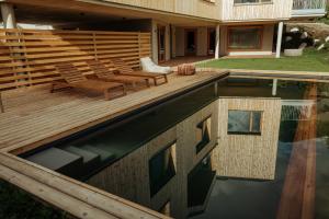 a wooden deck with chairs and a swimming pool at Haus Aerli in Ehrwald