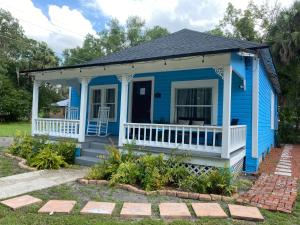een blauw tiny house met een witte veranda bij The Blue Aztec in Sanford