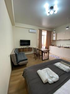 a bedroom with a bed and a table and a kitchen at Tbilisi cozy apartment in Tbilisi City