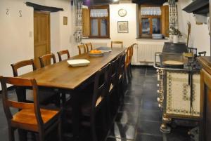 kuchnia z dużym drewnianym stołem i krzesłami w obiekcie Le Chat Roi - Charneux w mieście Herve