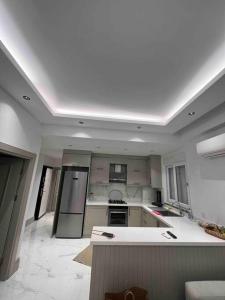 eine große Küche mit weißen Arbeitsflächen und Geräten in der Unterkunft Ilıca Side Site İçerisinde in Manavgat