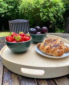 einen Tisch mit zwei Schalen Obst und einem Teller Essen in der Unterkunft Oasis in Buckinghamshire