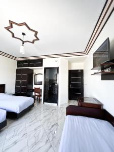 Habitación de hotel con 2 camas y TV en Maison d'hôtes familiale "Dar Aboulanwar", en El Jadida