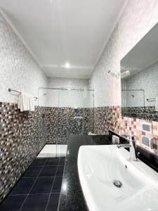 a bathroom with a sink and a shower at Maison d'hôtes familiale "Dar Aboulanwar" in El Jadida