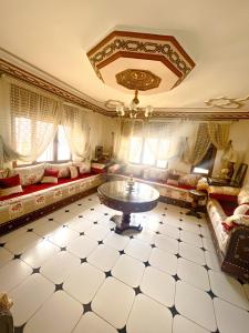 a living room with a couch and a table at Maison d'hôtes familiale "Dar Aboulanwar" in El Jadida