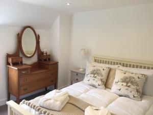 a bedroom with a bed with a mirror and a dresser at Middle Wymson House in Stratford-upon-Avon