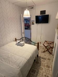 a bedroom with a bed and a flat screen tv at Habitacion Centrica Calle 8 Miami (2) in Miami