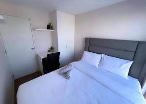 a bedroom with a white bed and a black chair at Encantador apartamento 2 habitaciones/ Cochera / Gimnasio in Lima