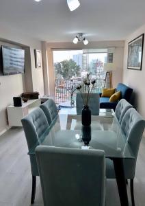 a living room with a glass table and chairs at Encantador apartamento 2 habitaciones/ Cochera / Gimnasio in Lima