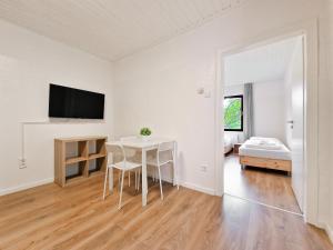 a white room with a table and a bed at RAJ Living - 1 , 2 and 3 Room Monteur Apartments in Duisburg