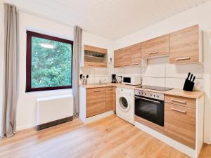 a kitchen with wooden cabinets and a window at RAJ Living - 1 , 2 and 3 Room Monteur Apartments in Duisburg