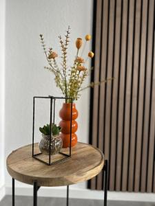 een tafel met een vaas met sinaasappels en bloemen erop bij Appartment Florida Nähe Düsseldorf, Messe, HBF, City, WIFI, HELIOS Hospital in Krefeld