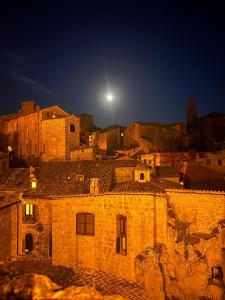 an old city at night with the moon in the sky at La casa di Agnese in Orvieto