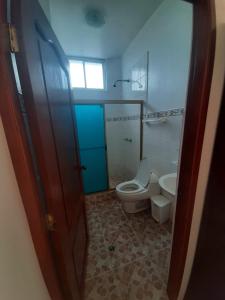 a bathroom with a toilet and a sink at Paraiso de Isabela in Puerto Villamil