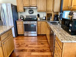 a kitchen with wooden cabinets and stainless steel appliances at Avenue of the Giants River View Home (#1) 