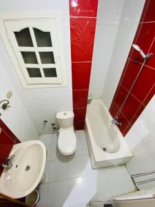 a red and white bathroom with a toilet and a sink at شقة للايجار اسكندرية in Alexandria