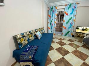 a living room with a blue couch and a checkered floor at شقة للايجار اسكندرية in Alexandria