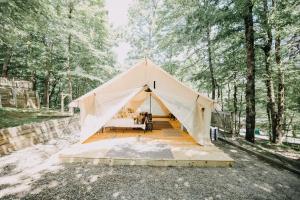 a tent in the woods with a bed in it at Timberline Glamping at Amicalola Falls in Dawsonville