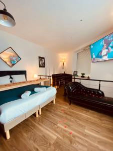 a living room with two beds and a flat screen tv at Mieuxqualhotel jacuzzi privatif La retro in Bordeaux