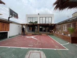 Wowo Loft Residence في برازافيل: رجل يقف على ملعب كرة سلة أمام مبنى